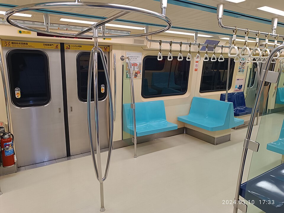 台北捷運車廂內部,淺藍色座椅與吊環