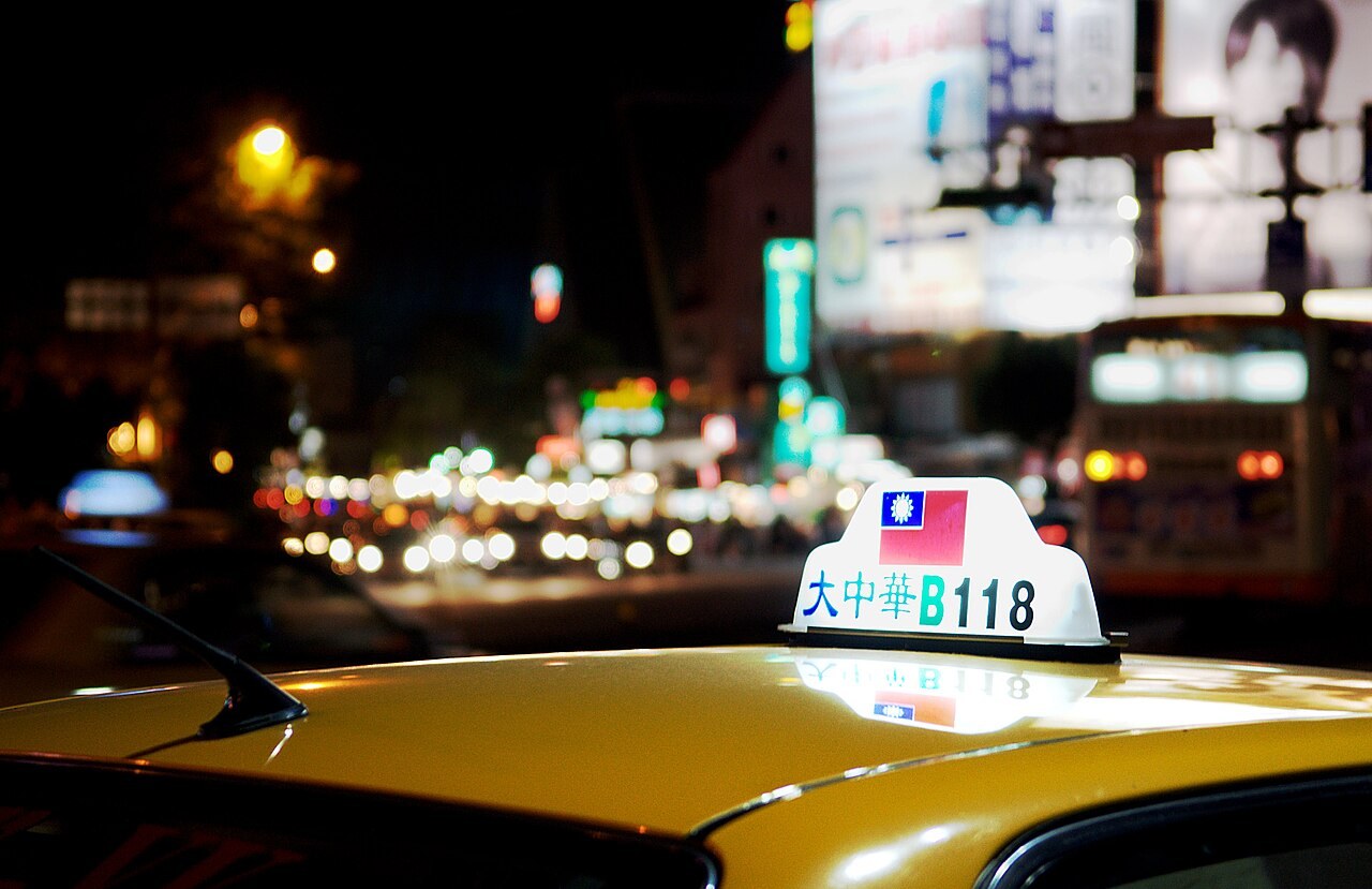 夜晚台北街頭，黃色計程車車頂的亮燈招牌